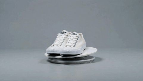 White retro sneaker rotating on a turntable — product GIF
